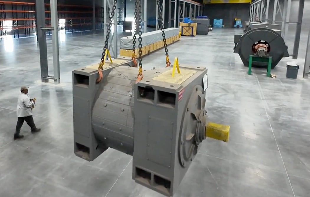 A large electrical motor on a crane in a warehouse